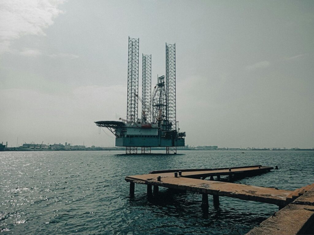 An offshore oil platform with industrial infrastructure in the background, representing large-scale energy operations where alternators are critical for backup and continuous power.
