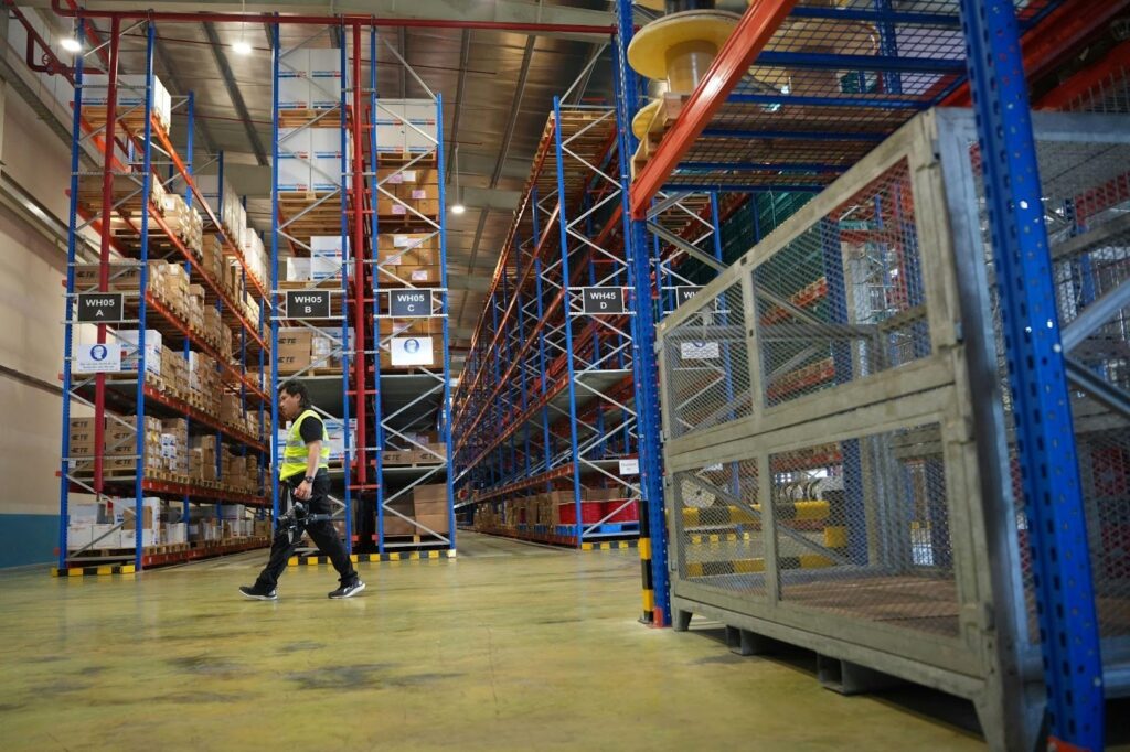  A logistics manager reviewing shipment data in an organized warehouse environment.